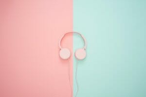 a pair of large pink headphones on a split pink and green background